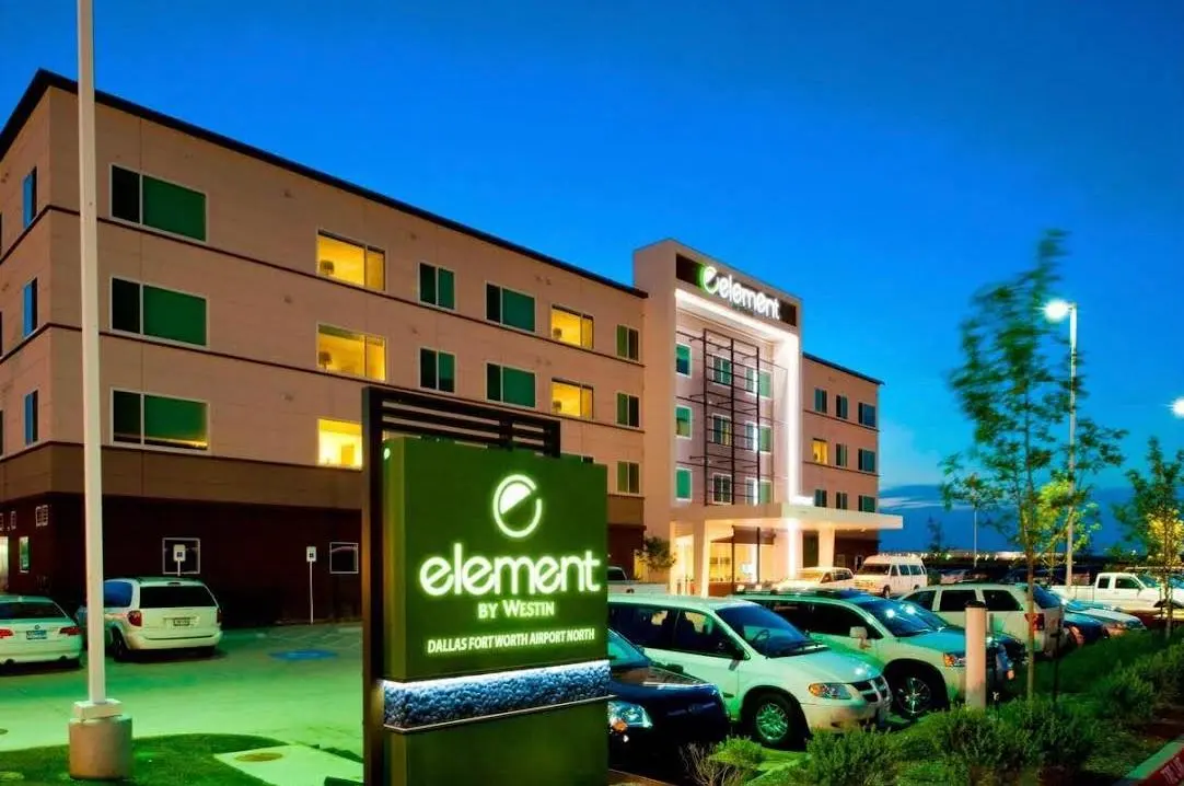 An Element by Westin at dusk, its lit green sign in the foreground and the entrance canopy behind